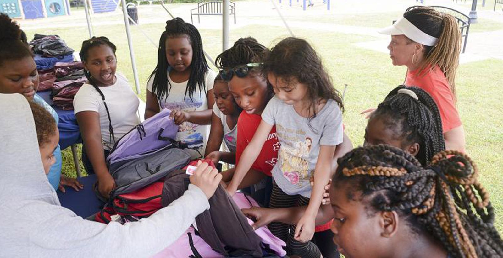 Children choosing backpacks at the Rock the Block back-to-school event